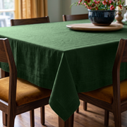 Forest Green Rectangular Linen Tablecloth in a Mid-Century Modern Dining Room with Walnut Chairs and Mustard Upholstery