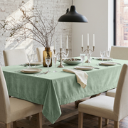 Mint Green Rectangular Velvet Tablecloth in a Transitional Dining Room with Cream Upholstered Chairs and White Brick Walls