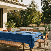 Steel Blue Rectangular Velvet Tablecloth in a Contemporary Patio Dining Area with Woven Leather Chairs