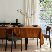 Terracotta Rectangular Heavy Weight Linen Tablecloth in a Modern Dining Room with Floor-to-Ceiling Curtains and Black Dining Chairs