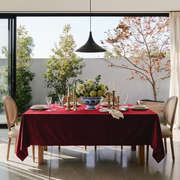Dark Deep Red Rectangular Velvet Tablecloth in a Transitional Dining Room with Floor-to-Ceiling Windows and Cane Chairs