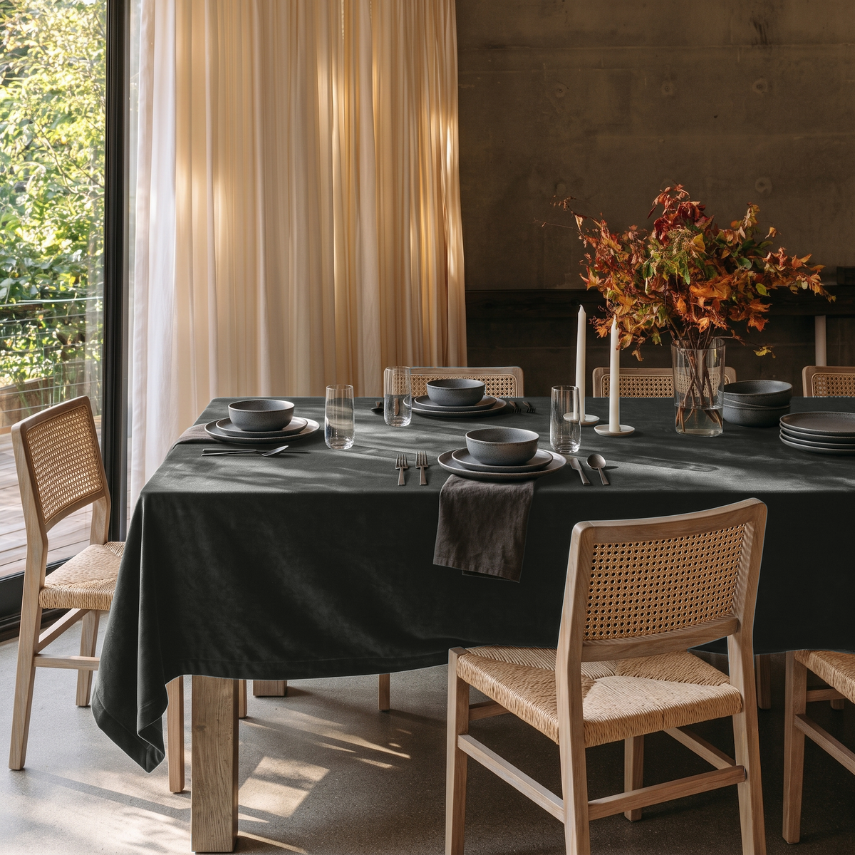 Dark Grey Rectangular Velvet Tablecloth in a Modern Organic Dining Room with Cane Chairs and Cream Curtains