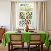 Light Green Rectangular Velvet Tablecloth in a Mid-Century Modern Dining Room with Cane Chairs and Cream Curtains