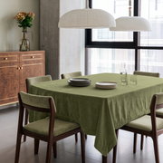 Olive Green Rectangular Velvet Tablecloth in a Contemporary Dining Room with Green Upholstered Chairs and Walnut Cabinet