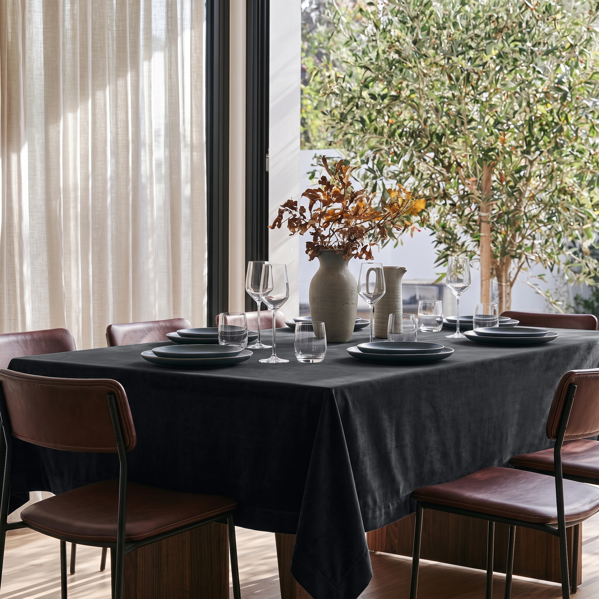 Steel Black Rectangular Velvet Tablecloth in a Modern Dining Room with Brown Leather Chairs