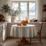 Natural Linen Round Tablecloth in a Cozy Kitchen Breakfast Nook with Snowy Mountain Views and Natural Wood Accents