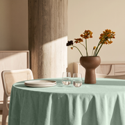 Mint Green Round Velvet Tablecloth in a Modern Dining Room with Cream Walls and Light Wood Furniture Accents