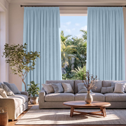 Sky Blue Linen Pencil Pleat Extra Long Curtains in a Contemporary Living Room with Gray Sectional Sofa, Wooden Coffee Table, and a Large Window Looking Out to Tropical Greenery