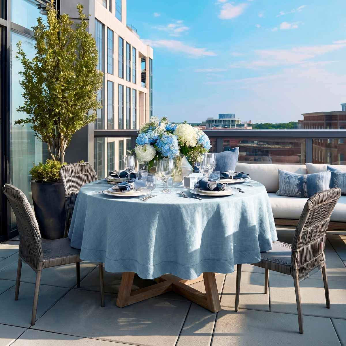 Sky Blue Linen Round Tablecloth in a Modern Rooftop Terrace Dining Area with Woven Seating