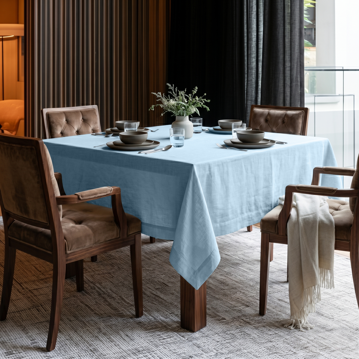 Sky Blue Square Linen Tablecloth in a Contemporary Dining Room with Brown Upholstered Chairs and Dark Floor-to-Ceiling Curtains