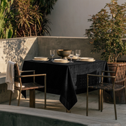 Black Square Velvet Tablecloth in an Outdoor Dining Area with Woven Chairs