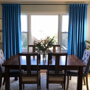 Steel Blue Velvet Curtains in a Dining Room with Neutral Walls and a Large Brown Table, Blue Upholstered Chairs