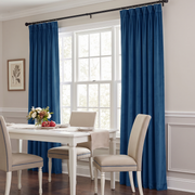 Elegant Steel Blue curtains frame a bright dining room window, beautifully complementing the white furniture and neutral interior