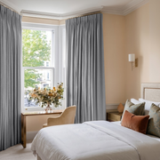 Stone Grey Linen Pencil Pleat Curtains in a Warm Beige Bedroom with Subtle Earthy Tones and Classic Interior Details - Blackout Lining
