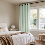 Mint Green Velvet Grommet Curtains in a Minimal Bedroom with White Bedding and a Cane Bench