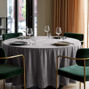 Grey Velvet Round Tablecloth in an Elegant Dining Room with Warm Beige Walls and Emerald Velvet Chairs