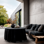 Black Velvet Round Tablecloth in a Modern Patio Lounge Setting with Raw Concrete Walls and Rustic Wood